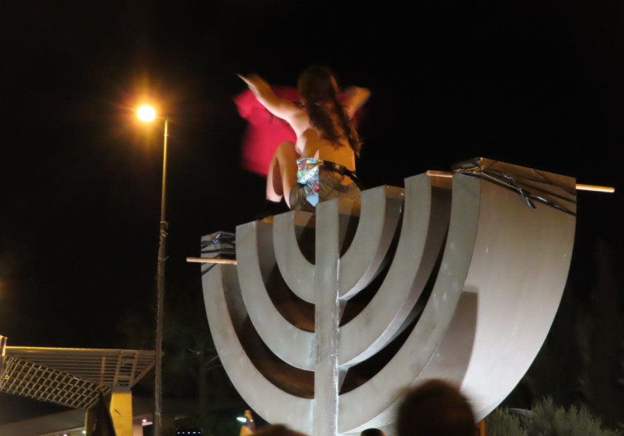 Naked woman on top of a menorah statue during Jerusalem protests , July 21, 2020 (IM TIRTZU)