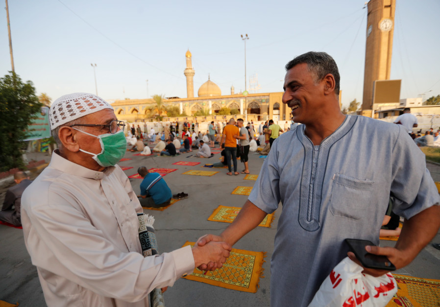 Iraqi worshippers exchange greetings after Eid al-Adha prayers on the street outside Abu Hanifa mosque in Baghdad Adhamiya district, during the outbreak of the coronavirus disease (COVID-19), in Iraq, July 31, 2020. (Credit: REUTERS/Thaier Al-Sudani)