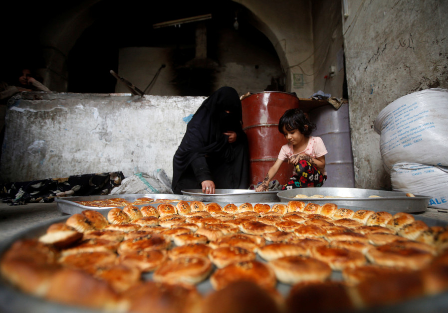 A woman and a girl prepare cookies for the Eid al-Adha festival at the old quarter of Sanaa, Yemen July 30, 2020. (Credit: REUTERS/Mohamed al-Sayaghi)