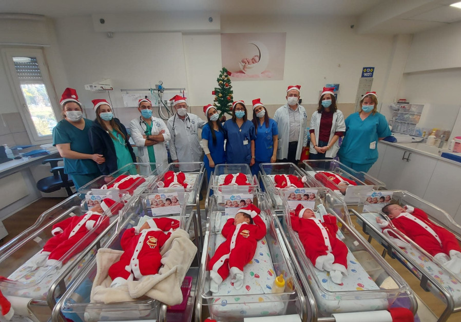 EMMS staff poses with babies in Christmas onesies (Credit: Courtesy)