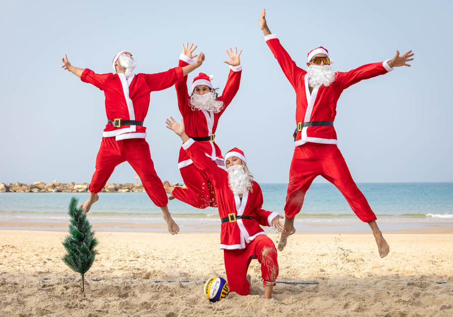  FourSanta-clad beachgoers are seen enjoying a day in Tel Aviv ahead of Christmas. (Photo credit: YoSee Gamzoo Letova/Tel Aviv Global & Tourism)