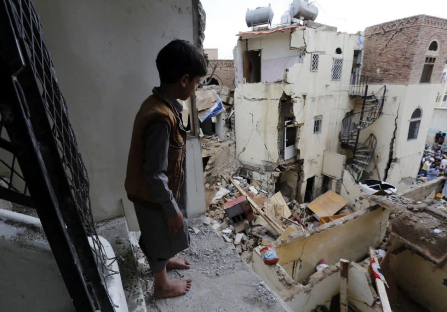 A Yemeni boy looks at the destruction caused by civil war at a World Heritage site in the Old City of Sana’a. (Photo credit: Felton Davis)