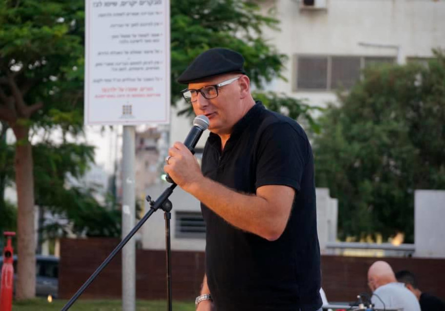 Shuki Gutman is seen reading poetry at an event in Netanya. (Credit: Courtesy)