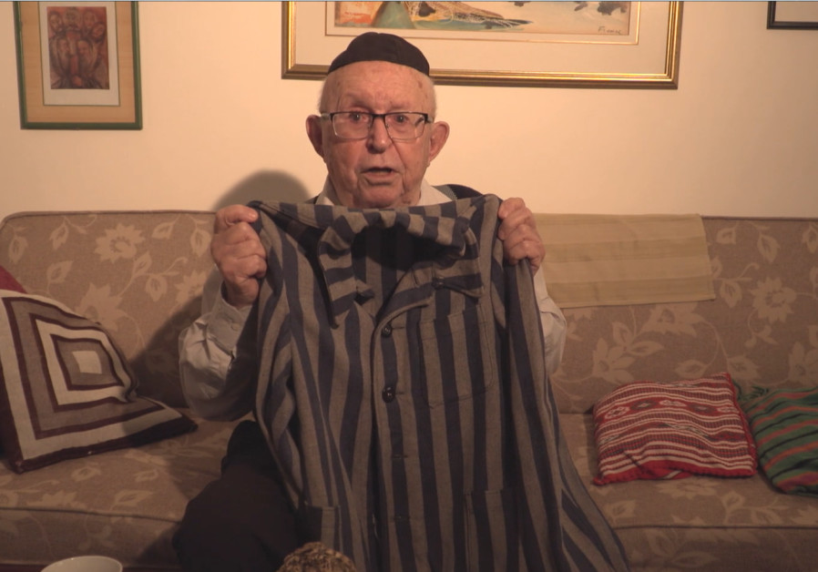 Avraham Carmii holding the concentration camp uniform that he displays at his Seder. (March of the Living)
