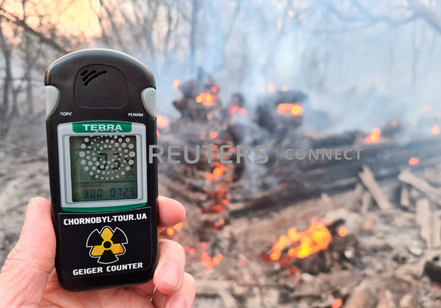 A geiger counter measures a radiation level at a site of fire burning in the exclusion zone around the Chernobyl nuclear power plant, outside the village of Rahivka, Ukraine April 5, 2020. (Photo credit: Yaroslav Yemelianenko/Reuters)