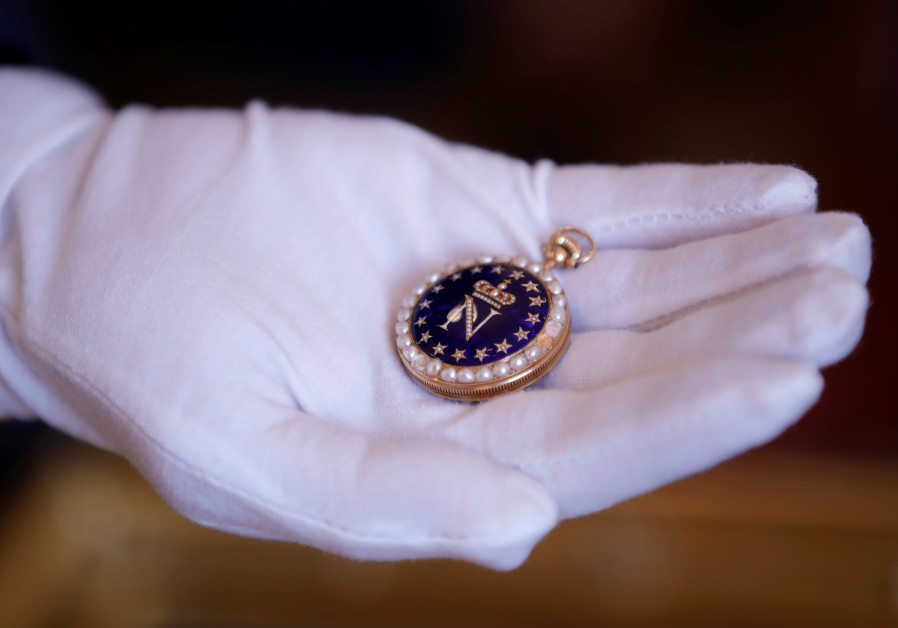 An auctionneer displays a round watch with the figure of French Emperor Napoleon I at Osenat auction house, before being put on auction for the bicentenary of Napoleon's death, in Fontainebleau, near Paris, France, April 30, 2021