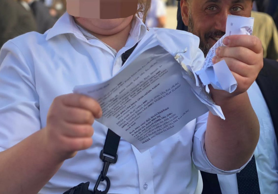 A haredi man ripping a prayer book belonging to Women of the Wall, June 11, 2021. (Credit: WOMEN OF THE WALL)