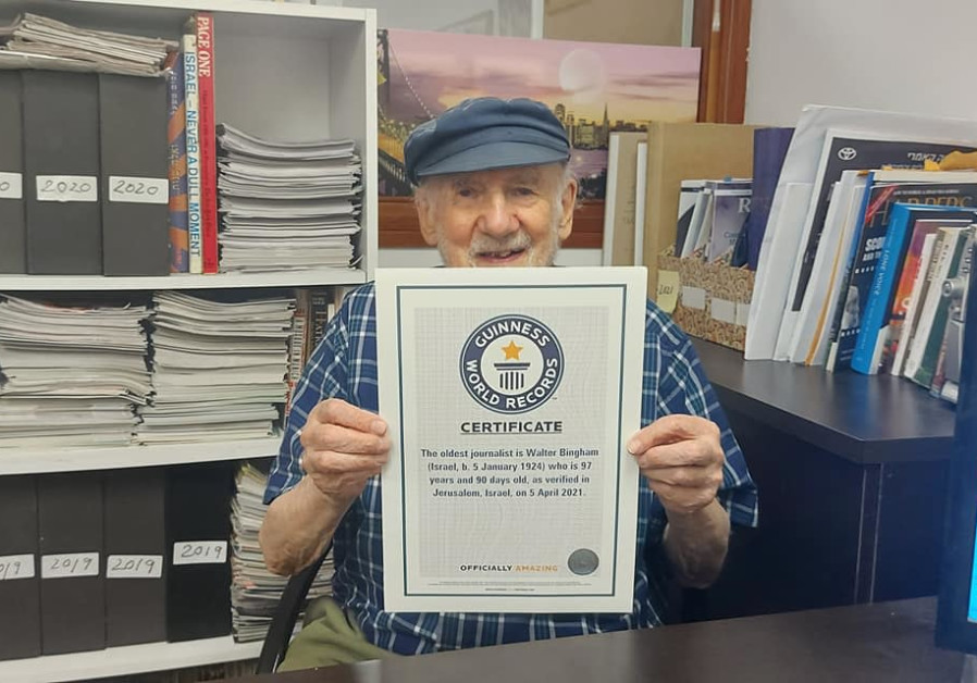 Walter Bingham holds up the certificate acknowledging his record as the oldest journalist in the world during a visit to ‘The Jerusalem Report’ (Credit: STEVE LINDE)