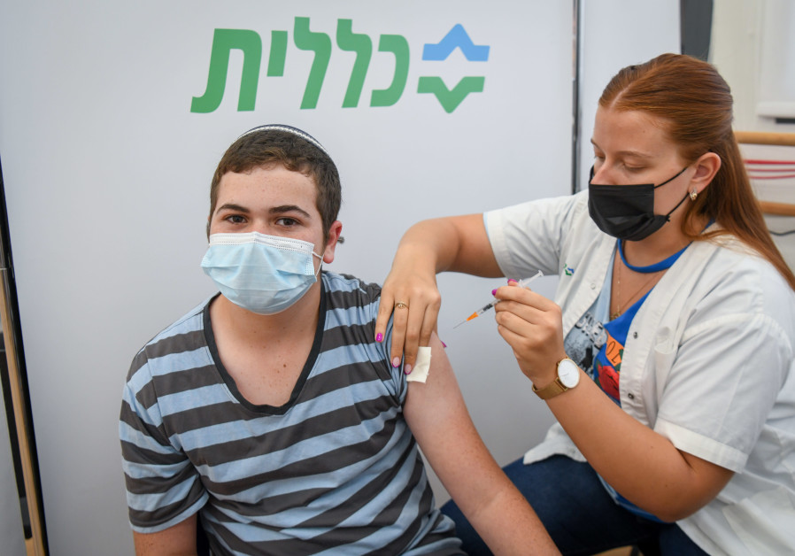 A young man receives a vaccine (Credit: Flash90)