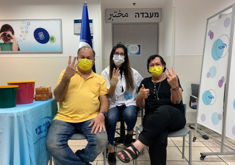 Yafit and Eli Shapira are the first to get vaccinated with the booster shot. The Maccabi vaccinating nurse is Moran Shapira their daughter in law. (Photo credit: MACCABI HEALTHCARE SERVICES)