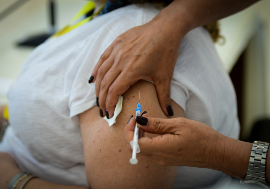 A member of the medical team at Mir Medical Center receives a coronavirus vaccine (Credit: Flash90)