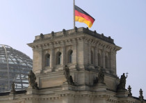 German flag flutters half-mast on top of the Reichstag building, the seat of the German lower house of parliament Bundestag in Berlin, March 25