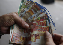A man counts New Israeli Shekels.