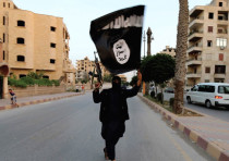 A MEMBER of ISIS waves the group’s flag in Raqqa recently