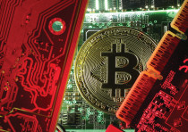  A coin representing the bitcoin cryptocurrency is seen on computer circuit boards in this illustrat