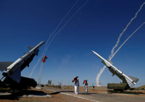 People watch S-300 air defense missile systems launching missiles 