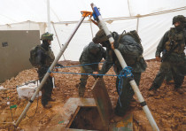 IDF SOLDIERS LIFT the cover off a hole into a cross-border tunnel dug from Lebanon into Israel, near