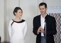 Syria's President Bashar al-Assad stands next to his wife Asma, as he addresses injured soldiers and