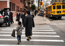 Pedestrians walk past a yeshiva in the South Williamsburg neighborhood of Brooklyn, April 9, 2019.