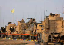 American soldiers stand near military trucks, at al-Omar oil field in Deir Al Zor