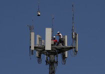 Workers install 5G telecommunications equipment on a T-Mobile tower in Seabrook, Texas. May 6, 2020