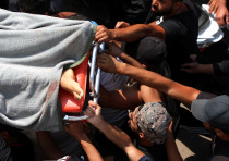 Mourners hold the body of a boy who died during Thursday's clashes, during his funeral in Khaldeh, Lebanon August 28, 2020.