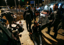 Los oficiales de policía chocan con los palestinos en la Puerta de Damasco en Jerusalén el 21 de abril de 2021. Los enfrentamientos estallaron después de que la policía israelí colocó barreras que impedían que las personas se sentaran en los escalones de la plaza fuera de la puerta. 