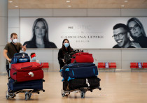 Passengers wearing masks push trolleys at the departures terminal at Ben Gurion International Airport, in Lod, near Tel Aviv, Israel.