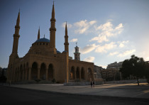 People walk along an empty street near al-Amin mosque, as Lebanon imposed a partial lockdown for two weeks starting on Friday in an effort to counter the spread of the coronavirus disease (COVID-19) which have spiralled since the catastrophic explosion at Beirut port, Lebanon August 21, 2020