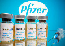 En esta ilustración, tomada el 31 de octubre de 2020, se ven viales con una etiqueta que dice "COVID-19 / Vacuna contra el coronavirus / Solo inyección" y una jeringa médica frente al logotipo de Pfizer.