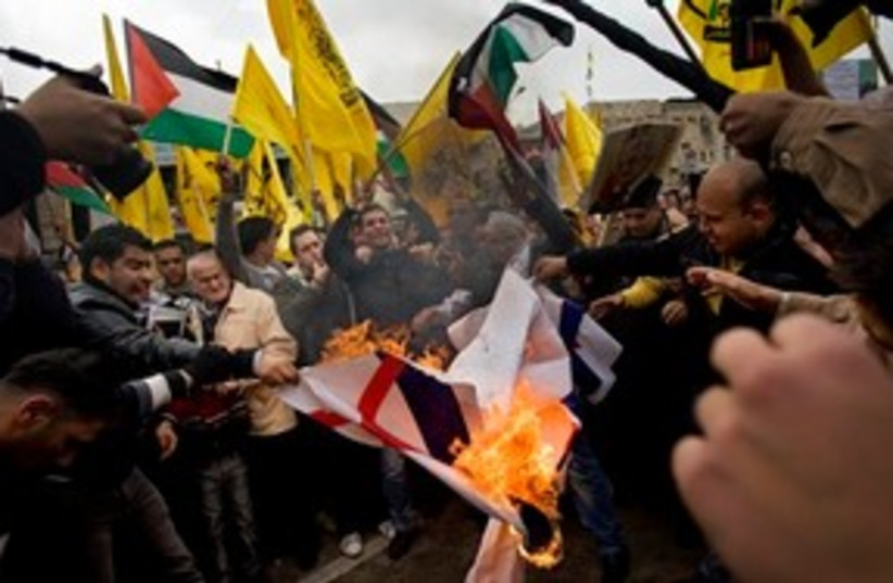 Palestinians burn Al-Jazeera logos in rally