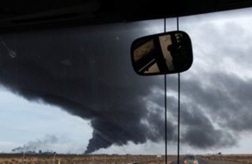 Libya black smoke from Gaddafi (R) 311 (photo credit: Chris Helgren / Reuters)