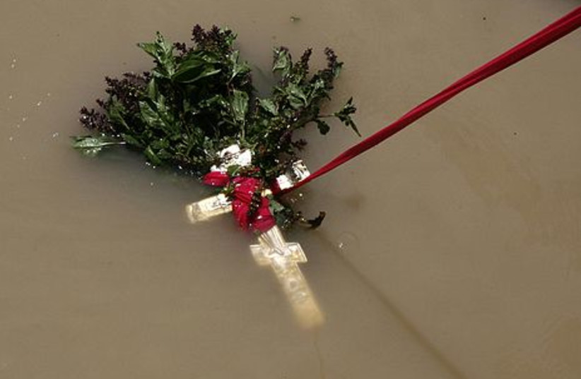 A crucifix is pulled out of the Jordan River