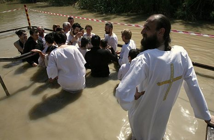 Christian pilgrims stand in the Jordan River