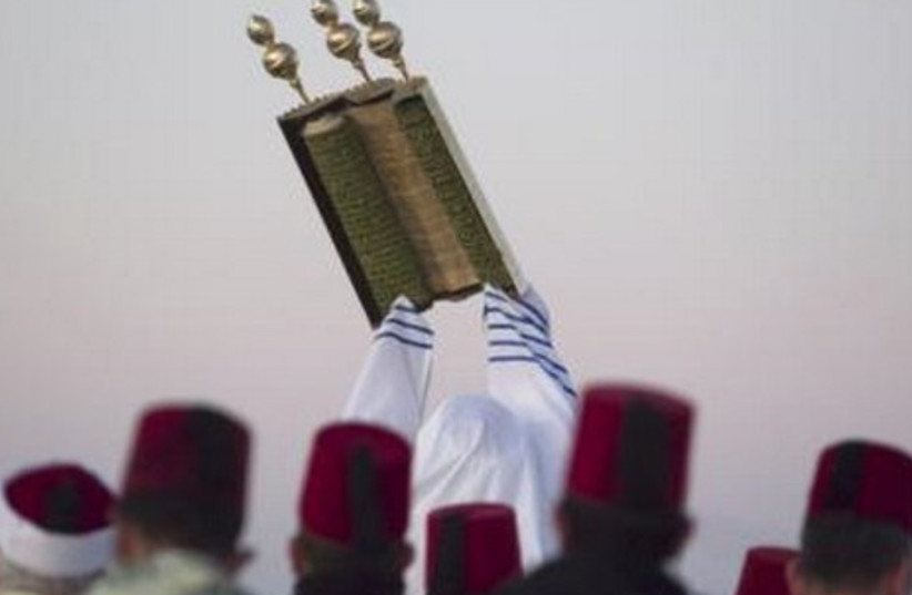 A member of the Samaritan sect raises a Torah.