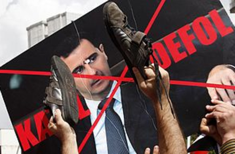 Defaced Syria Assad Poster 311 (photo credit: REUTERS)