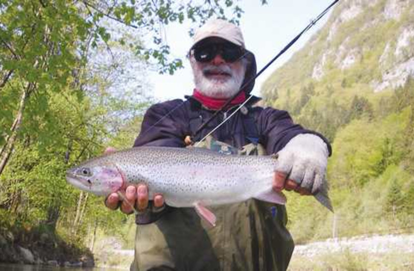 Norman Cohen with his catch, a rainbow trout. (photo credit: Courtesy)
