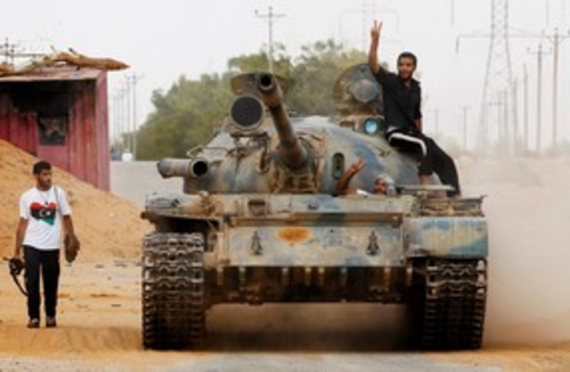 Libyan rebles move a tank 311 (R) (photo credit: REUTERS/Bob Strong)