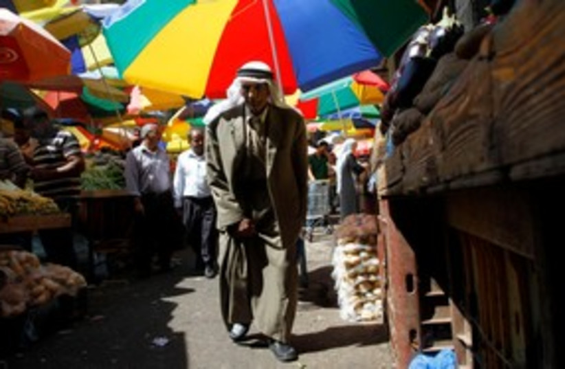 Palestinian man walks through the market (photo credit: REUTERS)