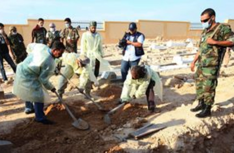 Medical, militia officials dig for bodies in Tripoli 311 (R) (photo credit: REUTERS/Ismail Zitouny)
