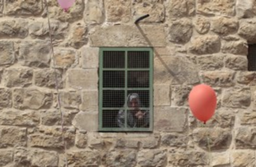 Palestinian woman looks out window in Hebron_311 (photo credit: The Jewish Community of Hebron)