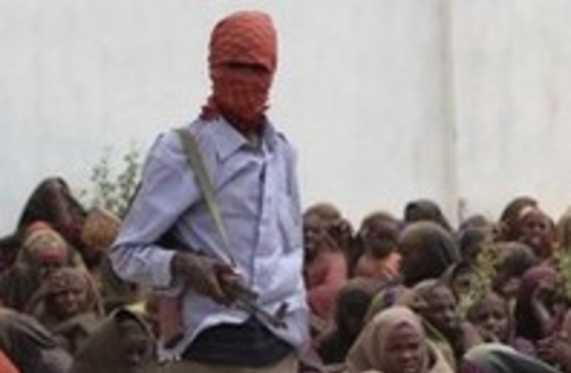 Al-Shabaab fighter at  food distribution camp Somalia 300 (photo credit: Faisal Omar/Reuters)