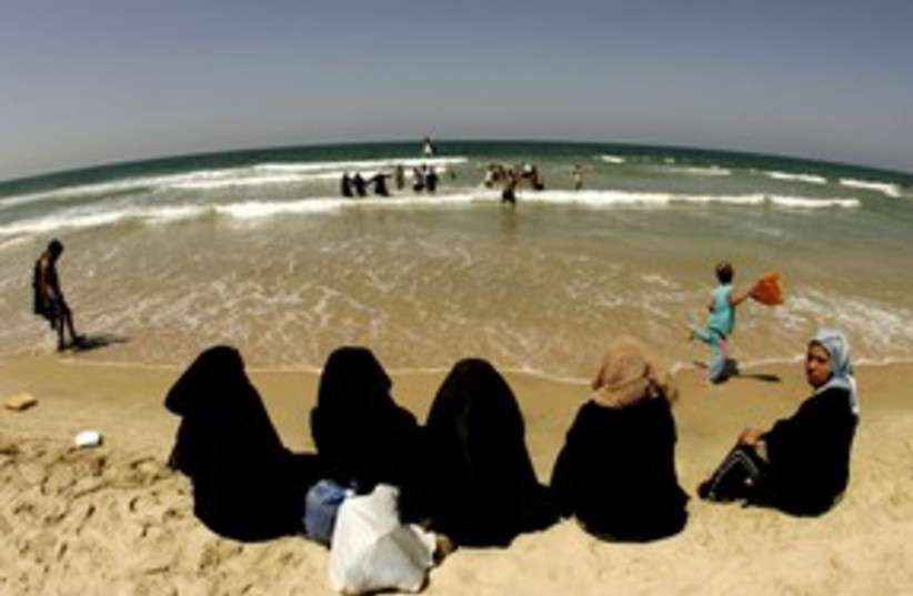 Palestinian women sit at Gaza Strip beach 311 (R) (photo credit: REUTERS/Yannis Behrakis)