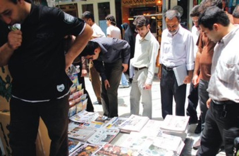 Iranians read newspapers in Tehran 390 (photo credit: Reuters)
