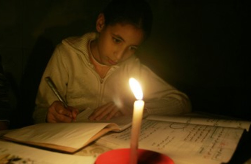 Palestinian girl studies by candle light in Gaza_390 (photo credit: Reuters)