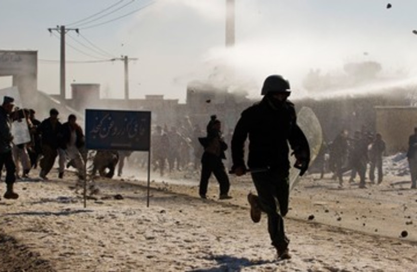 Afghan policeman flees protesters 390 (photo credit: REUTERS)