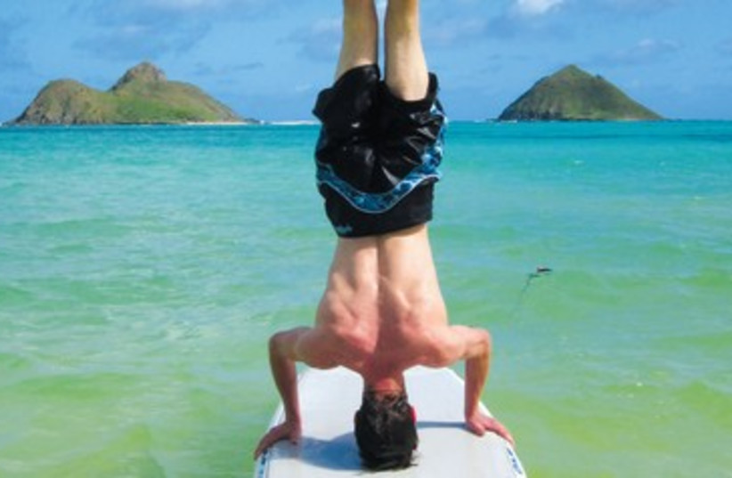 Surfer doing a headstand 390 (photo credit: Reuters)