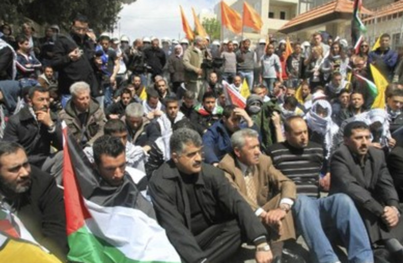 Palestinian protesters sitting in Bethlehem road