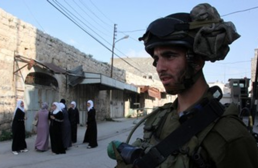 Soldier, Arab women in Hebron_370 (photo credit: Marc Israel Sellem/The Jerusalem Post)