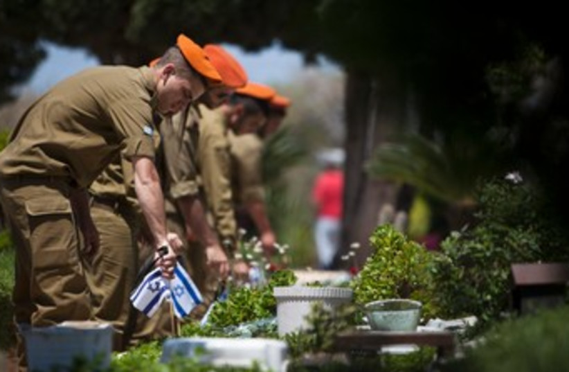Soldiers lay flags on Graves on Remembrance Day 370 (photo credit: REUTERS)